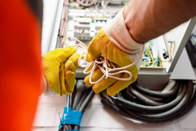 cropped view of electrician in gloves holding wires near electrical box 1024x684 1 768x513